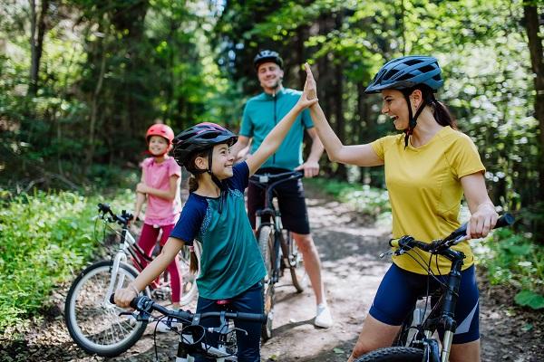 Jeune famille avec des enfants qui font du vélo dans la nature
